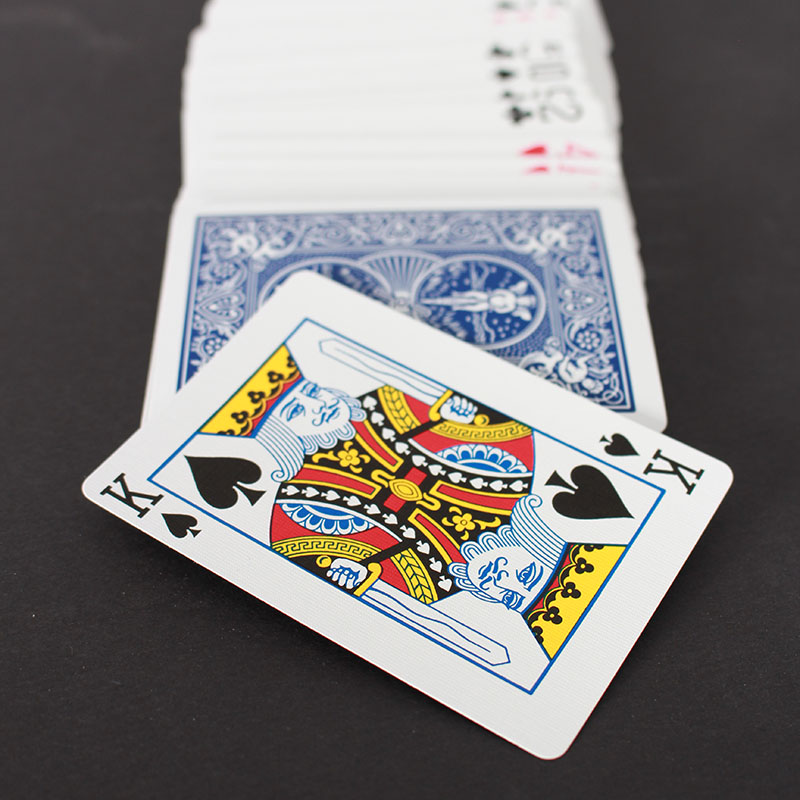 A photo of playing cards splayed out in a straight line downwards, the king card is on top