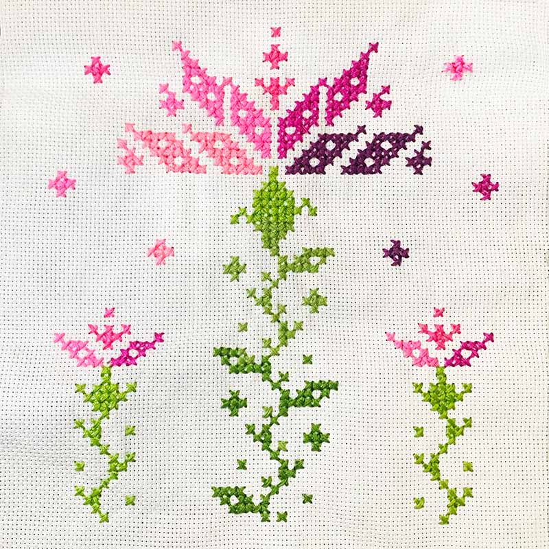 An image of a thistle illustrated in cross-stitch technique